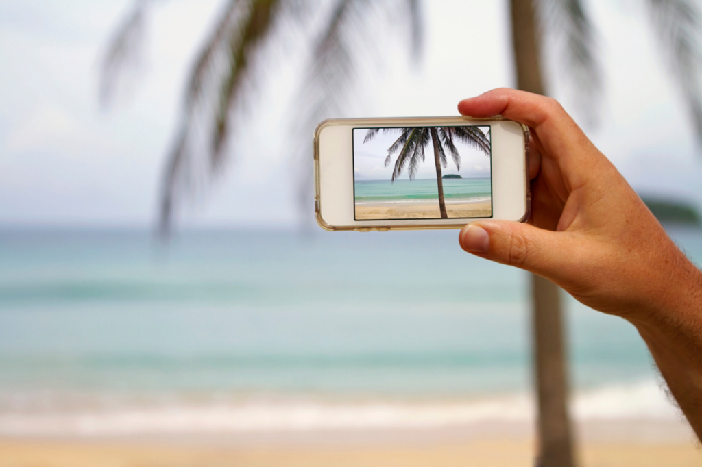 Smart phone taking photo of a beach