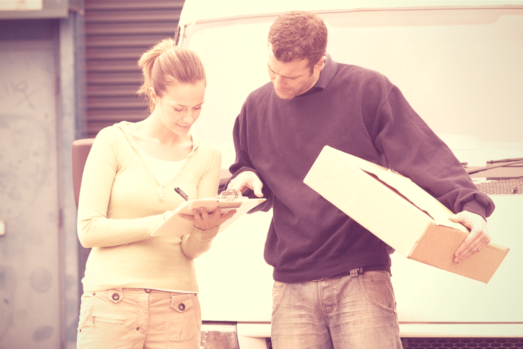 Man watching as woman signs for parcel delivery