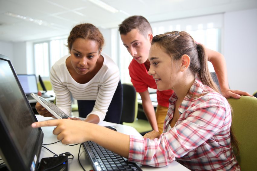 interns working together at a computer during summer internship