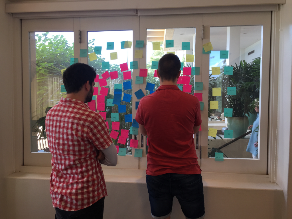 Two men looking at a display board of postit notes
