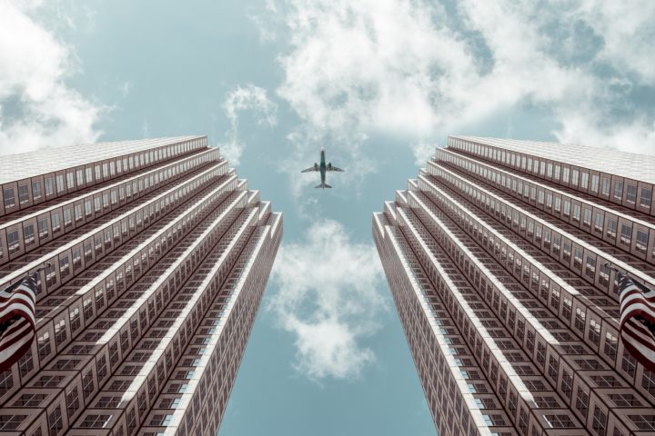 plane flying over skyscrapers